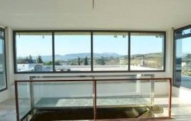 Una habitación con muchas ventanas y barandilla.