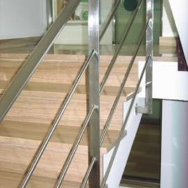 Una escalera con barandilla de acero inoxidable y escalones de madera.