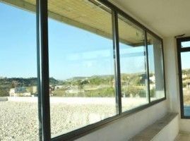 Una habitación con muchas ventanas y vista a las montañas.