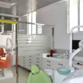 En un consultorio dental hay una silla dental verde.