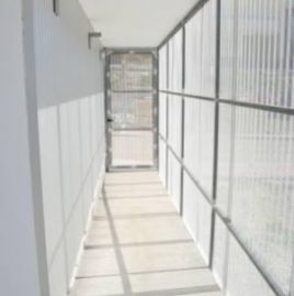 Un largo pasillo con paredes blancas y una puerta.