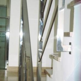 Una escalera con barandilla y escalones de acero inoxidable.