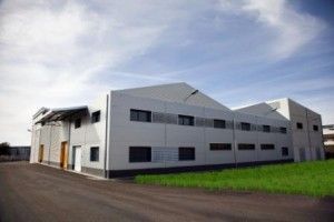 Un gran edificio blanco se encuentra encima de un exuberante campo verde.