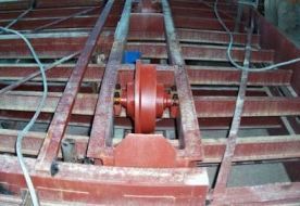 Una rueda roja está colocada encima de una estructura de metal.