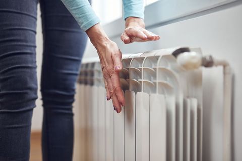 Femme qui touche un radiateur