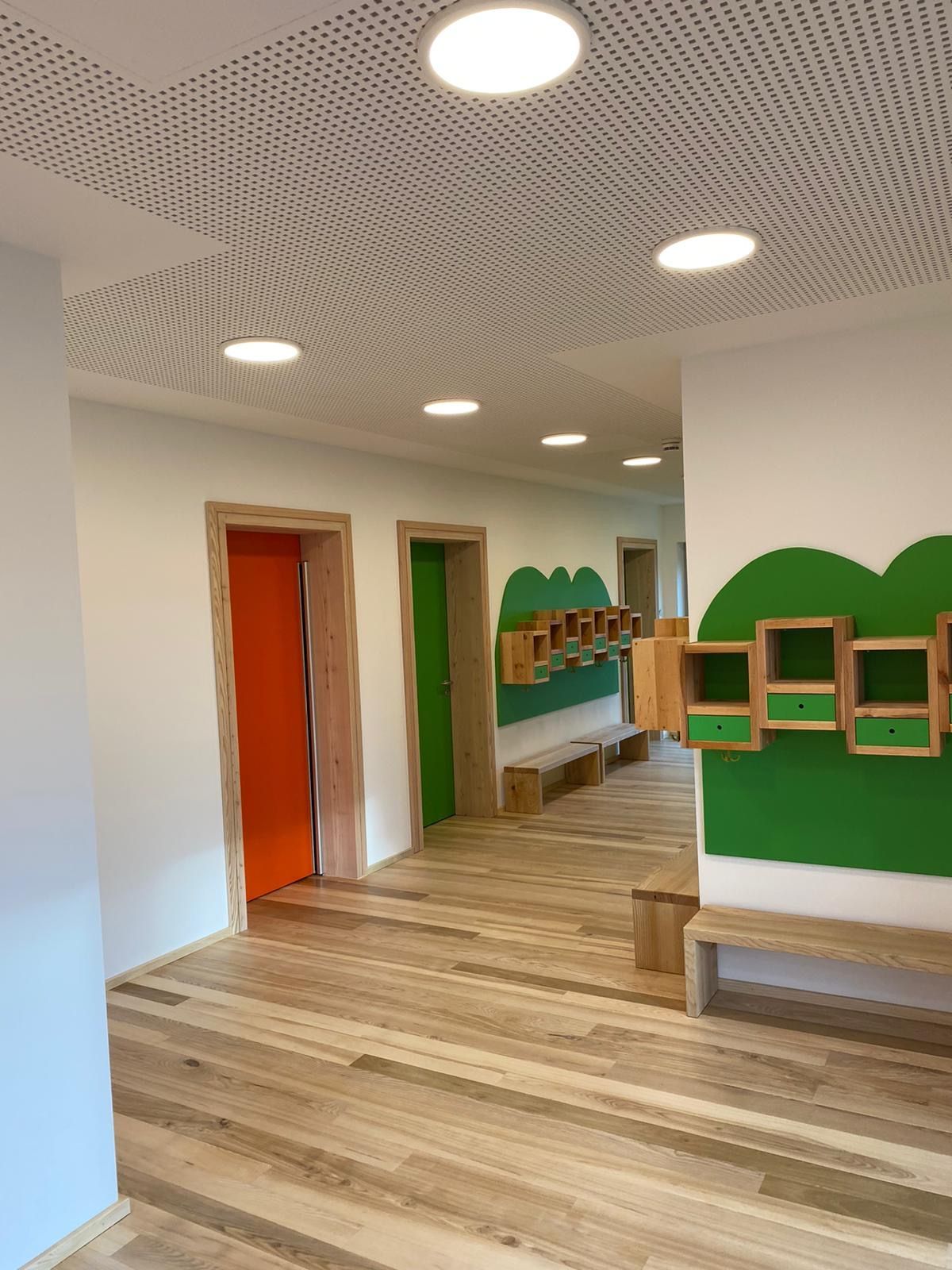 Flur Kindergarten mit Kästen und Bänken vor einer Tür