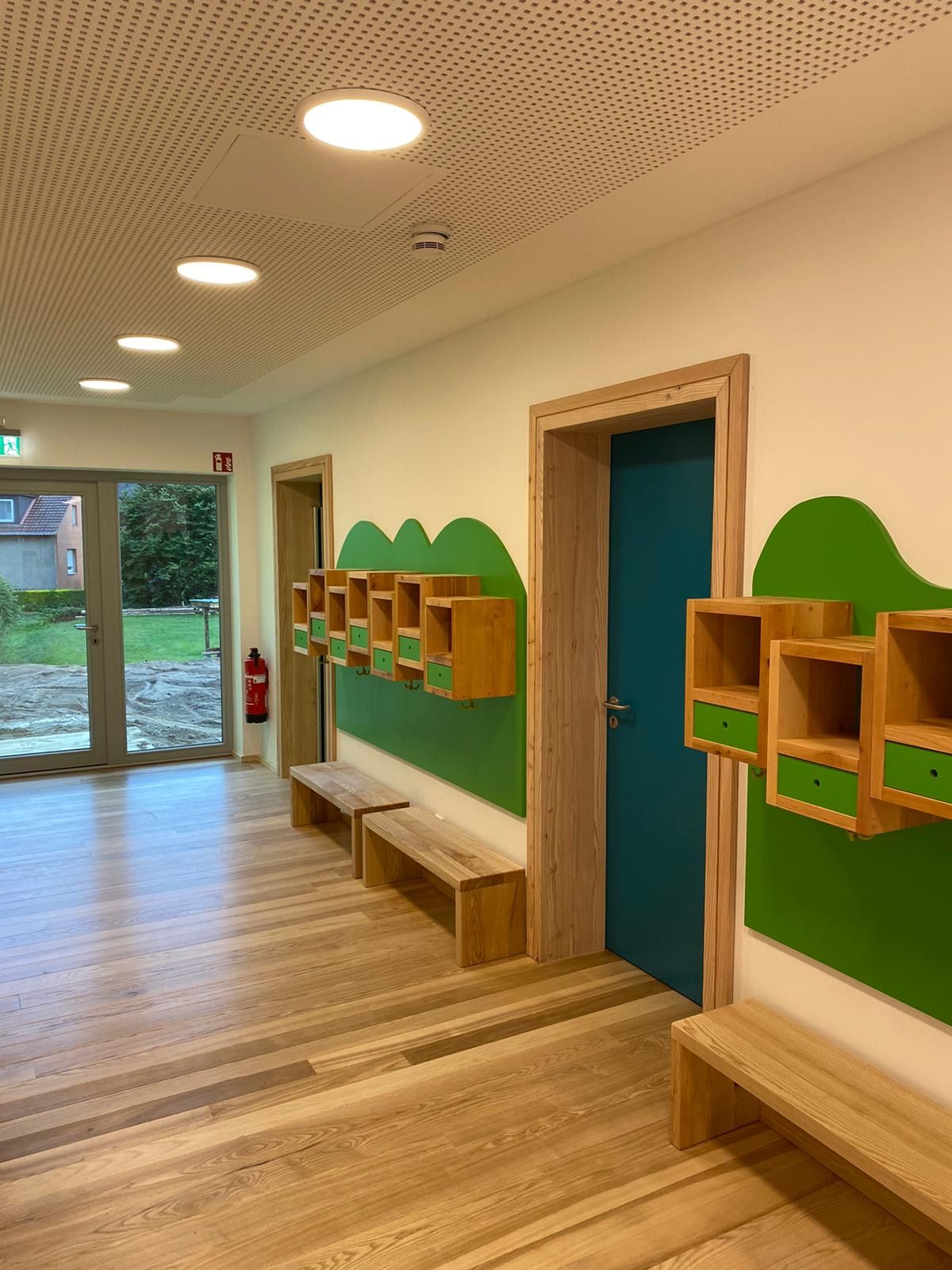 Flur Kindergarten mit Kästen und Bänken vor einer Tür