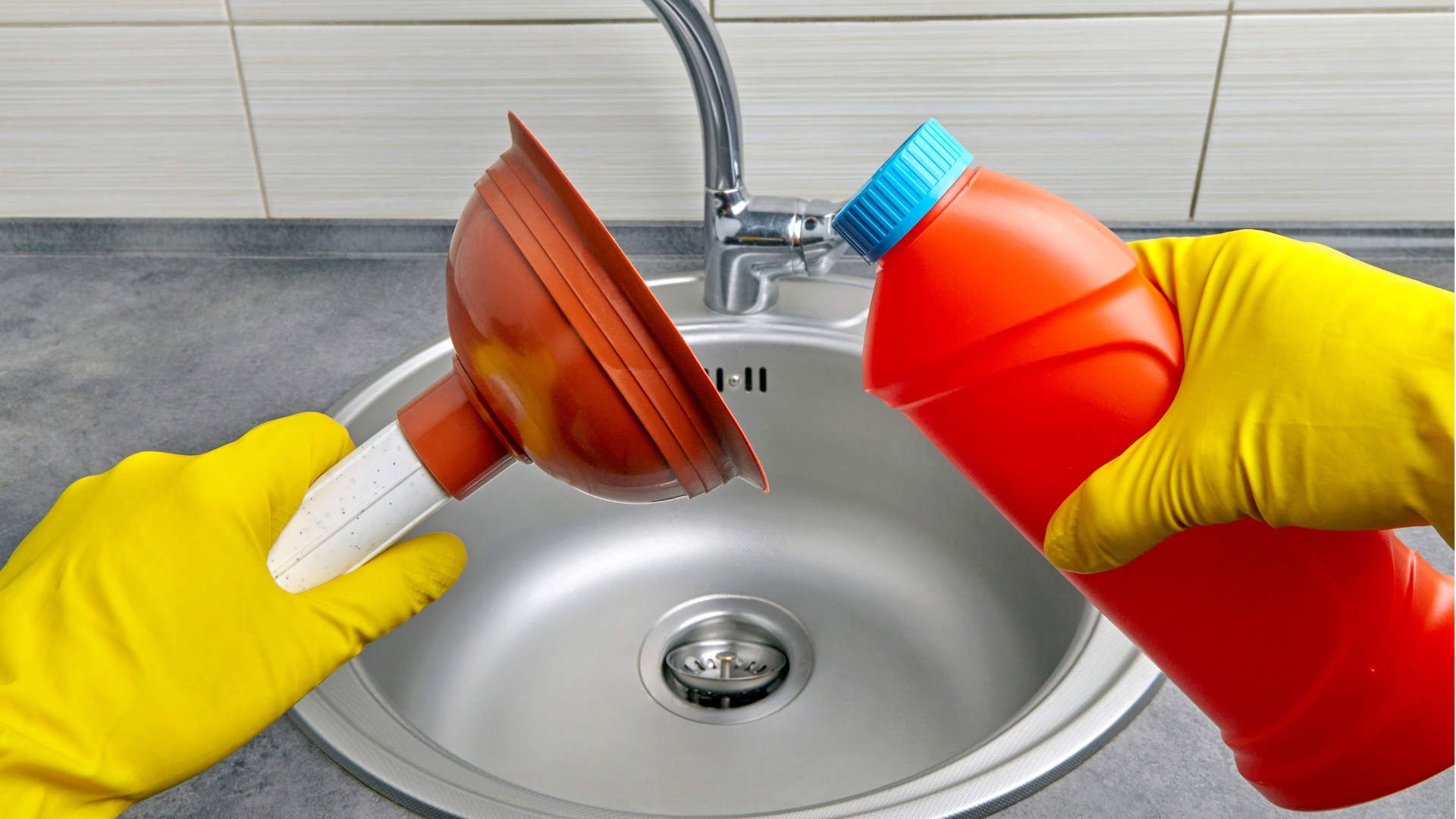 Eine Person in gelben Handschuhen ist im Begriff, mit einem Pümpel und Bleichmittel ein verstopftes Waschbecken zu reinigen.