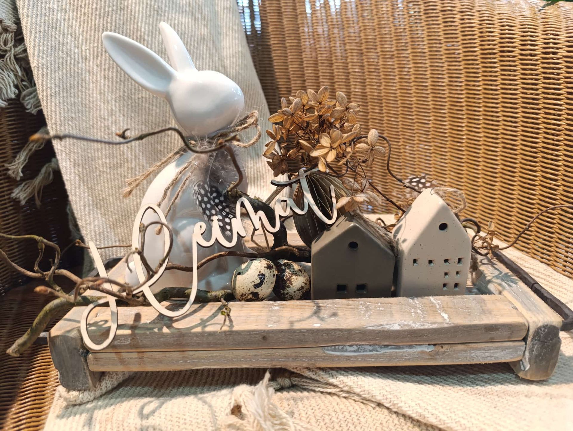 Ein Holztablett mit einem Hasen, Häusern und Blumen darauf.