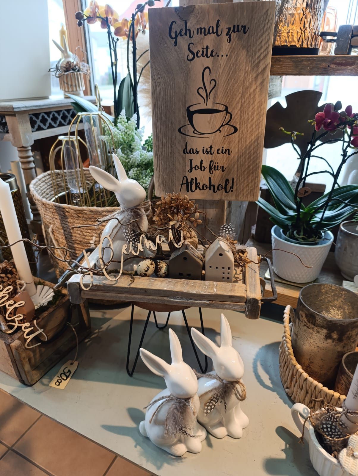 Auf einem Tisch steht ein Holzschild mit einer Tasse Kaffee darauf.