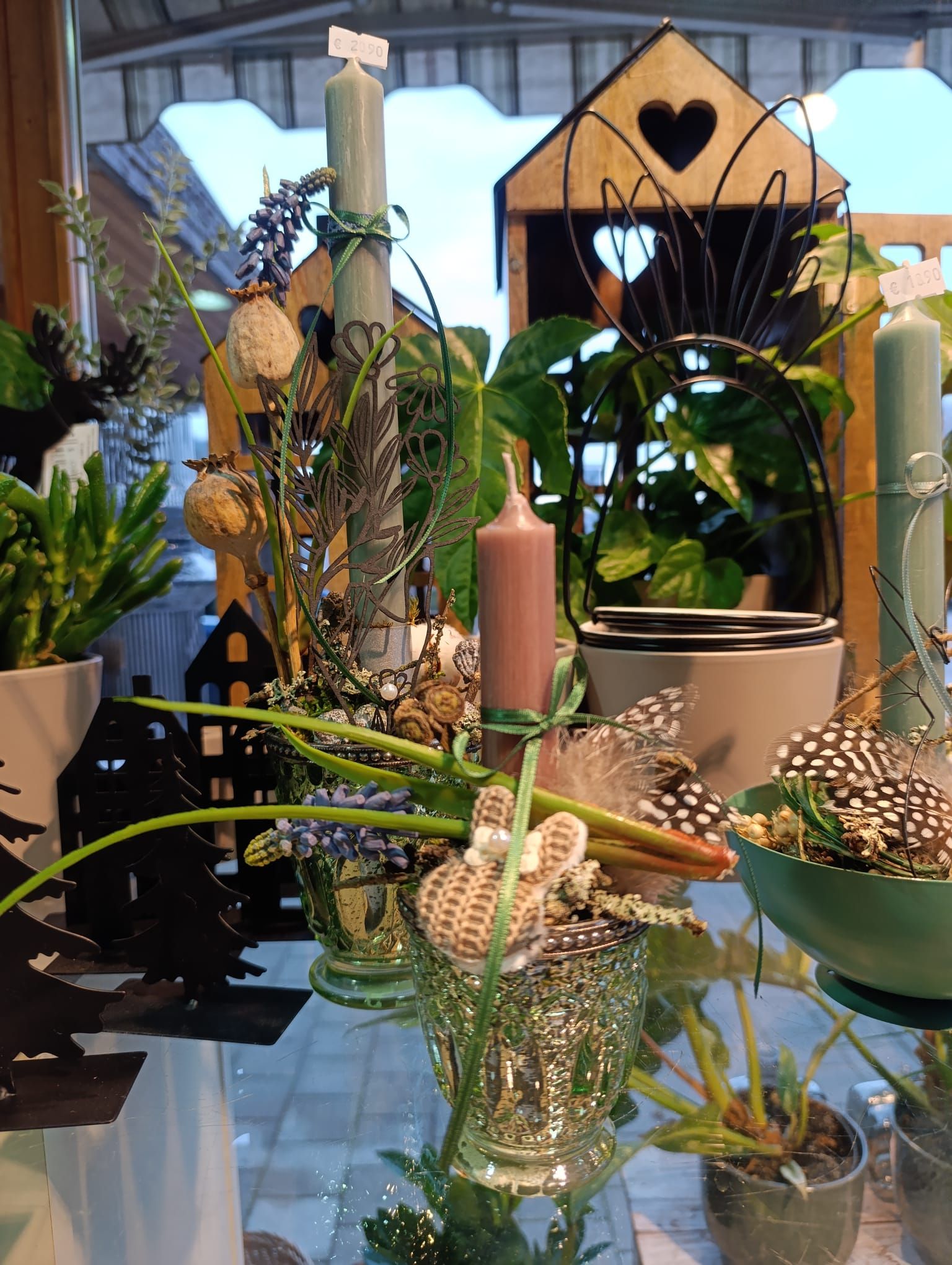 Ein Tisch mit Topfpflanzen und Kerzen.