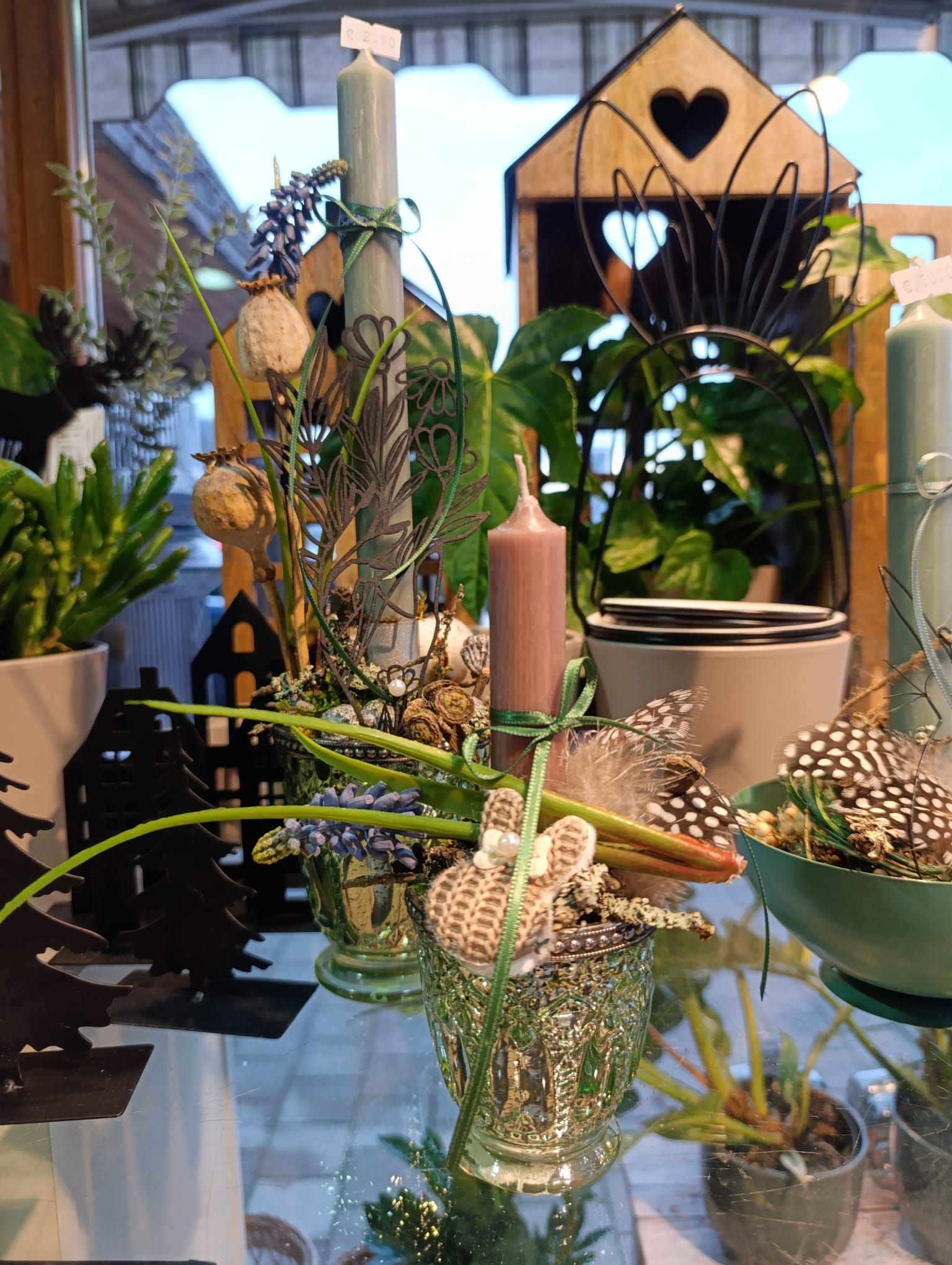 Ein Tisch mit einer Blumenvase und Kerzen darauf.