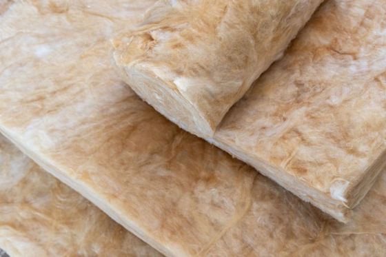 Des couches d'un isolant beige pliées et empilées les unes contre les autres.