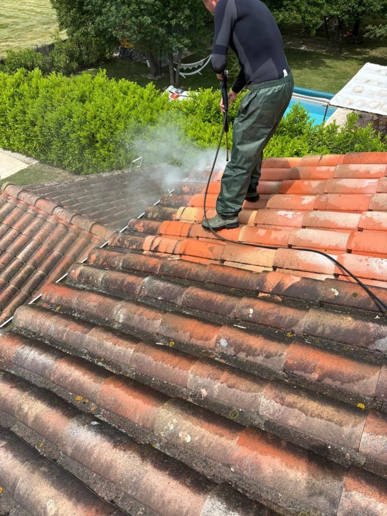 Toiture en tuiles rouges avec plusieurs puits de lumière, vue d'en haut dans un quartier résidentiel.