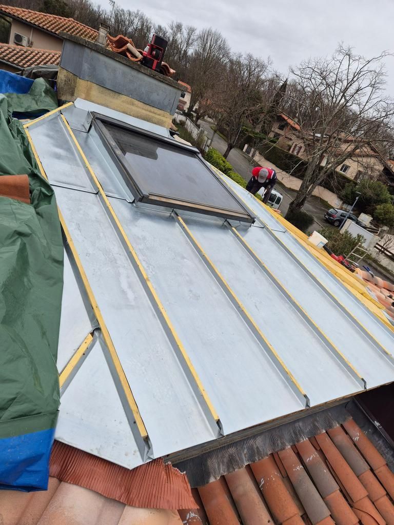Installation de panneaux solaires sur un toit en tuiles de terre cuite, avec des panneaux argentés et des ouvriers à l'œuvre.