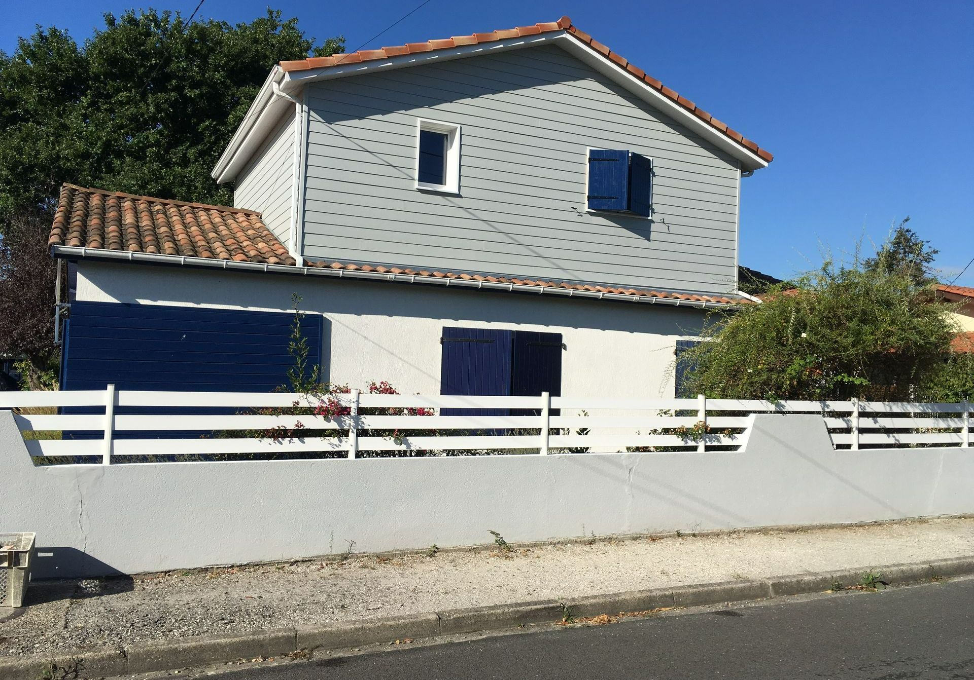 Une maison à volets bleus avec une surélévation