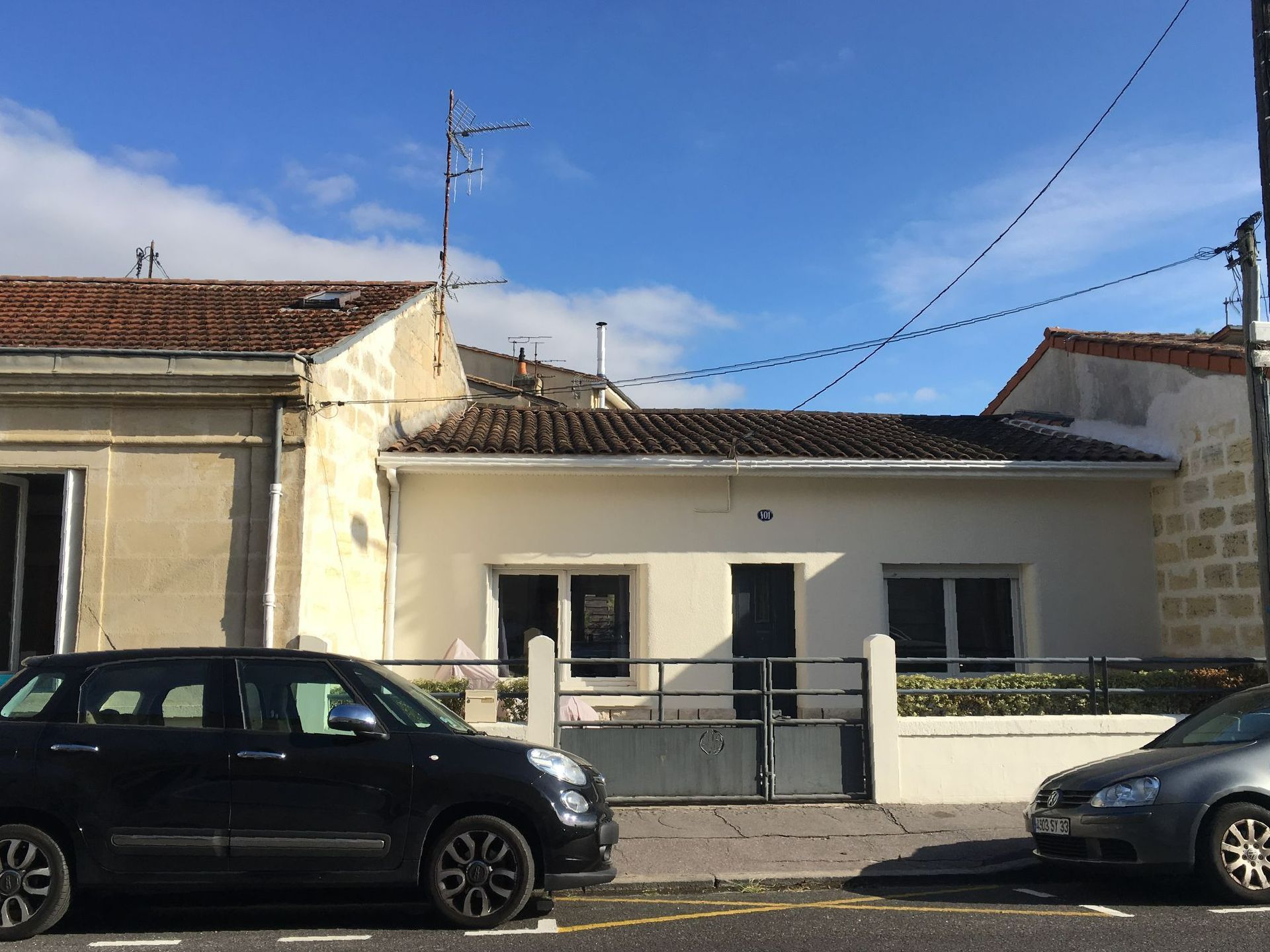 Une maison avec deux voitures devant