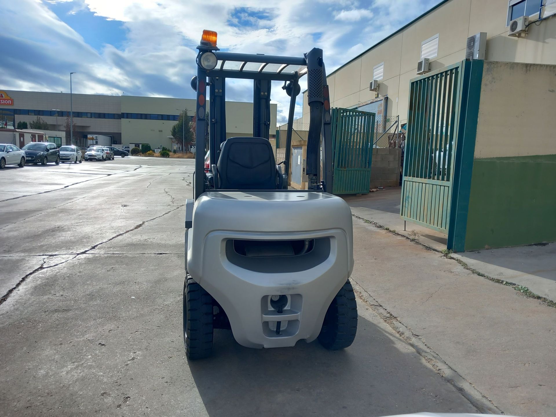 Una carretilla elevadora blanca está estacionada frente a un edificio