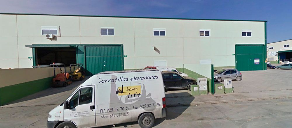 Una camioneta blanca está estacionada frente a un edificio.