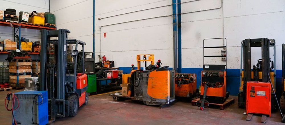 Un montón de carretillas elevadoras están estacionadas en un almacén