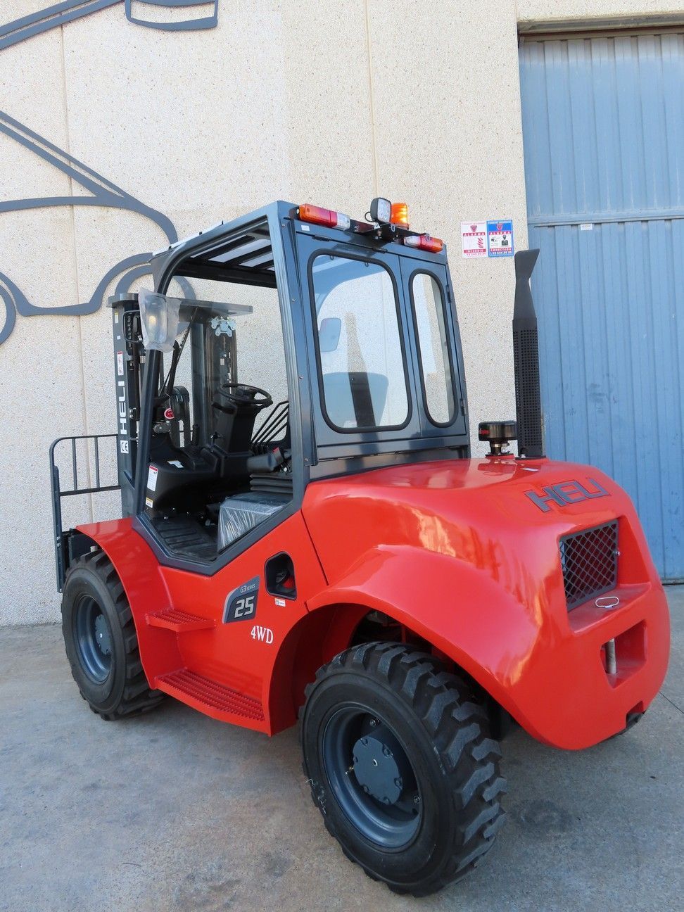 Una carretilla elevadora roja está estacionada frente a un edificio