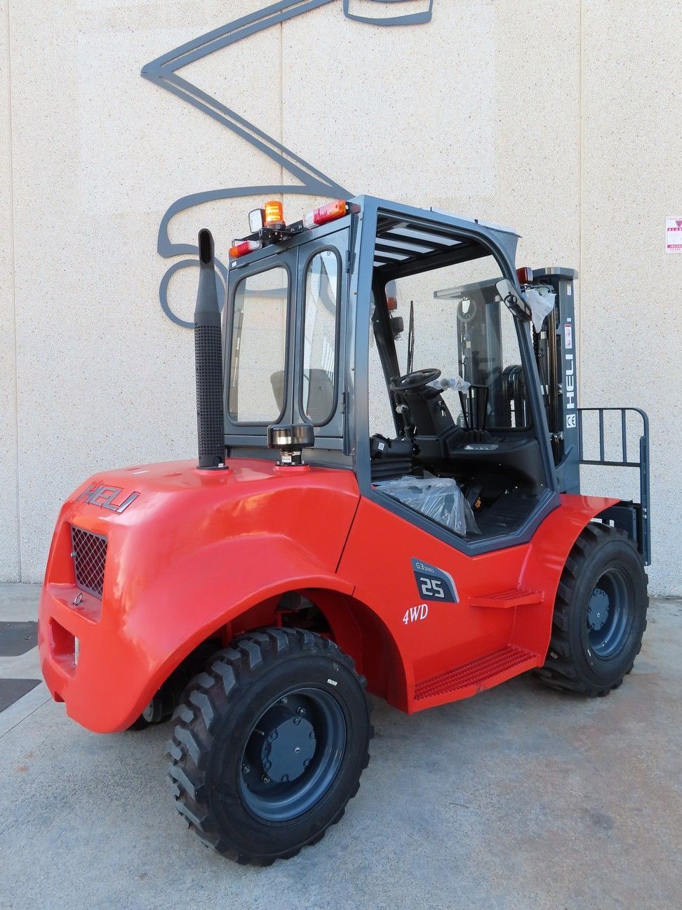 Una carretilla elevadora roja está estacionada frente a un edificio