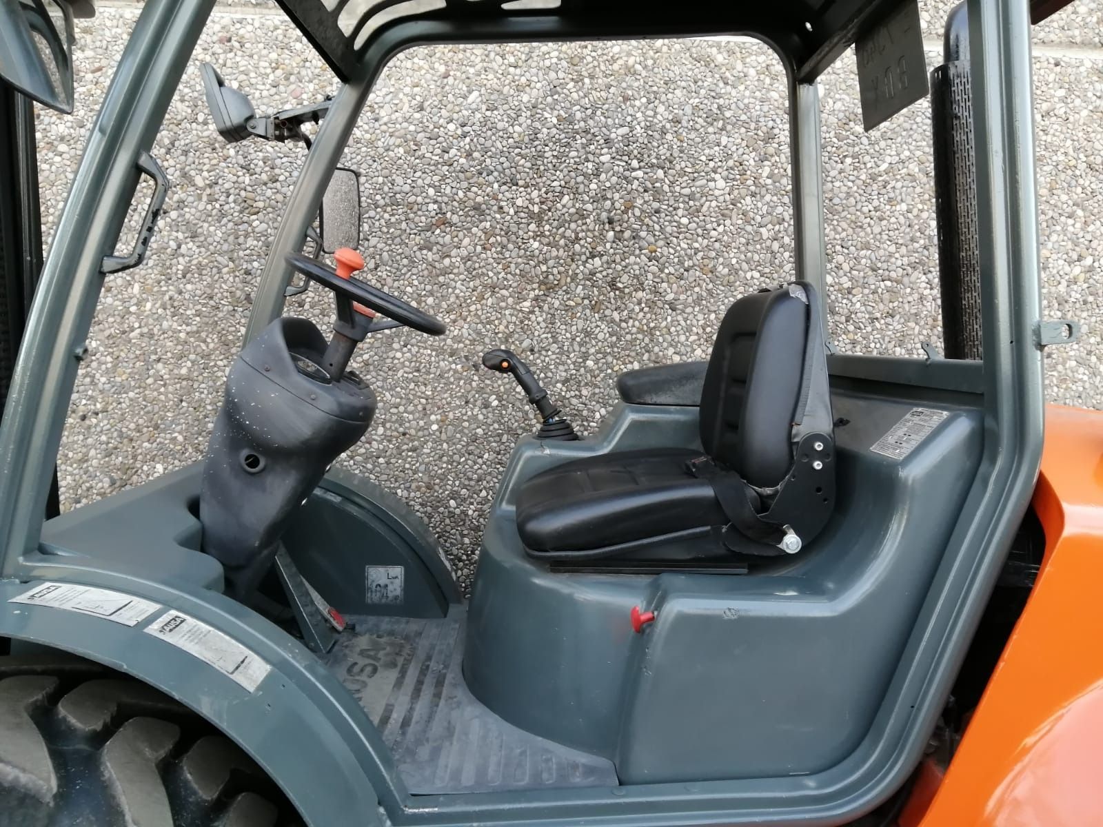 Una carretilla elevadora está estacionada delante de un muro de hormigón.