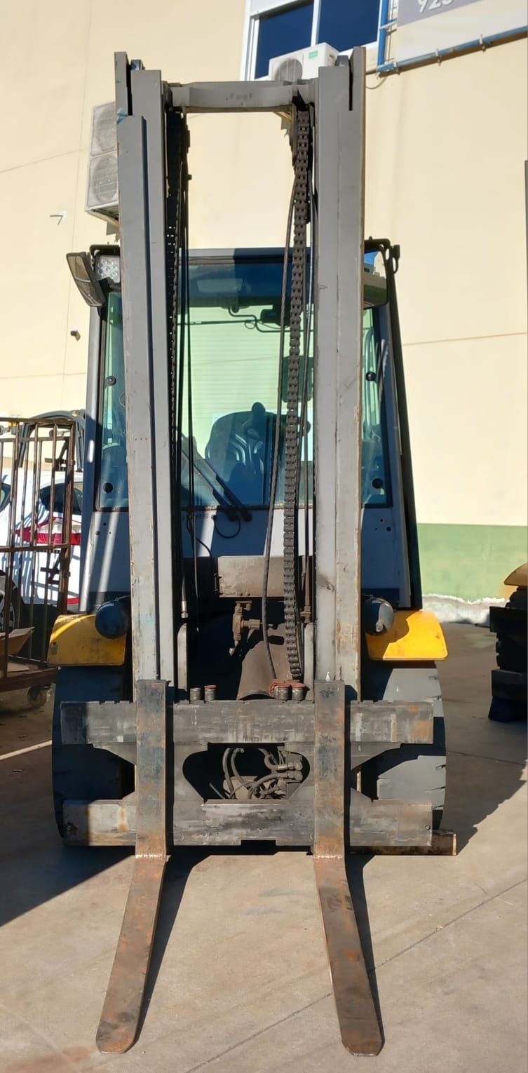 Una carretilla elevadora está estacionada delante de un edificio.