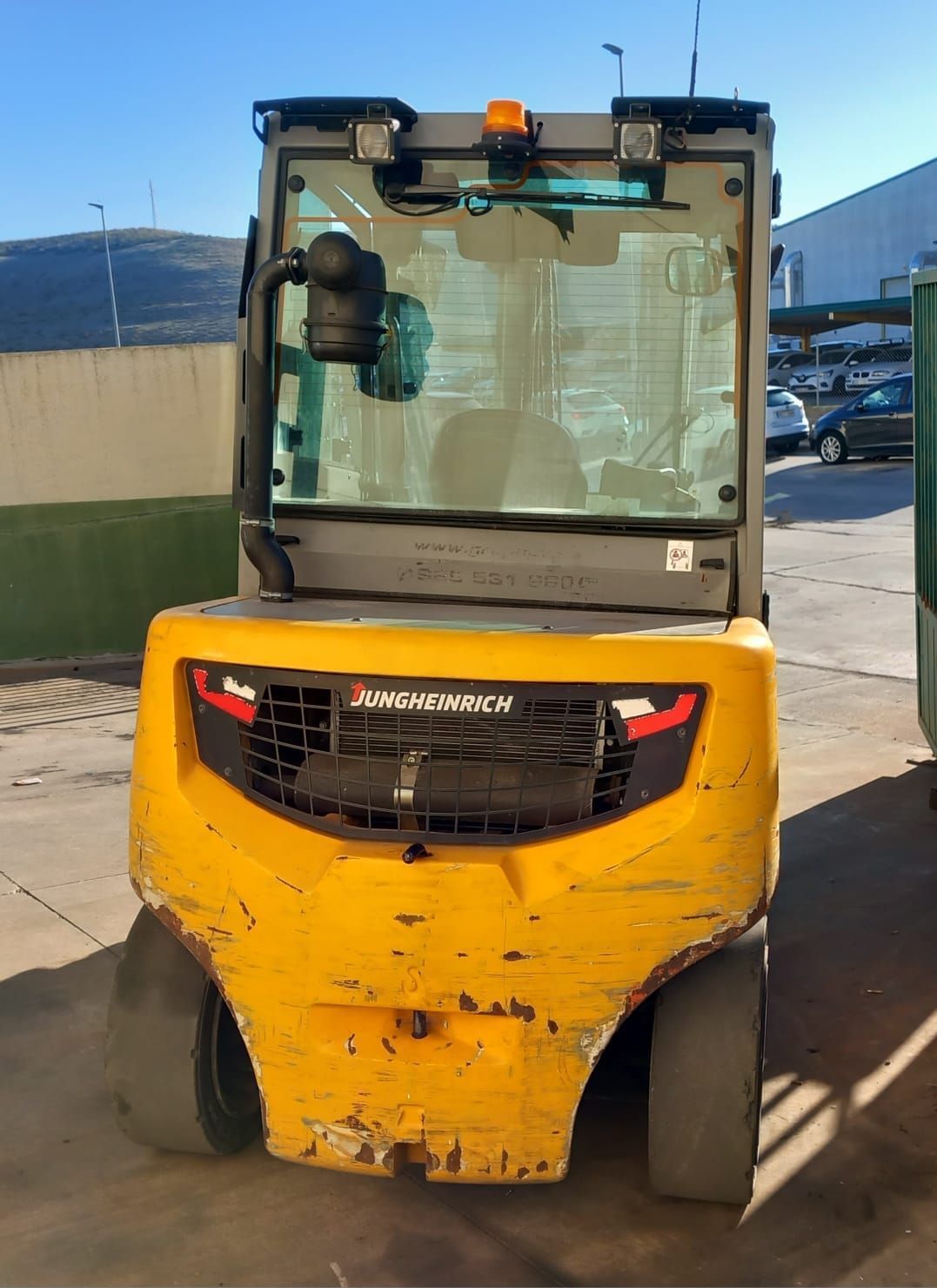 Una carretilla elevadora amarilla está estacionada en un estacionamiento.