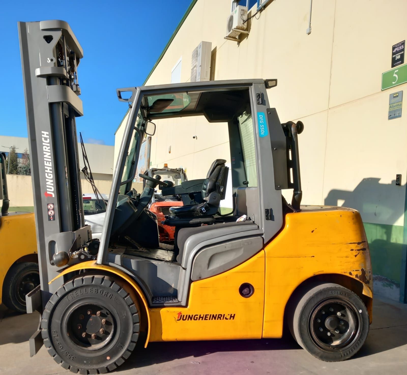 Una carretilla elevadora amarilla está estacionada frente a un edificio