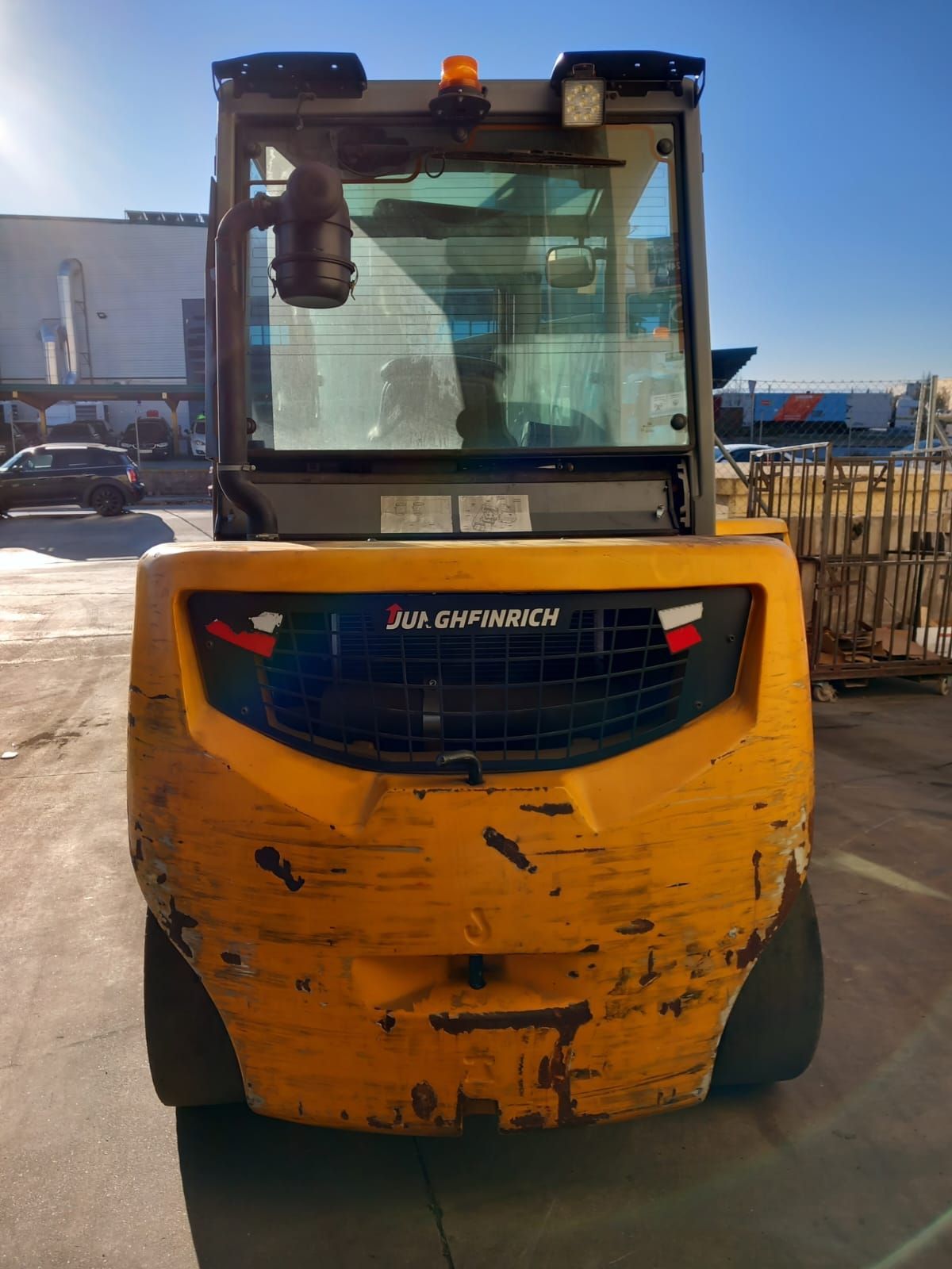 Una carretilla elevadora amarilla está estacionada en un estacionamiento