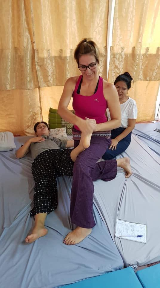 Una mujer está dándole un masaje a un niño en una cama.