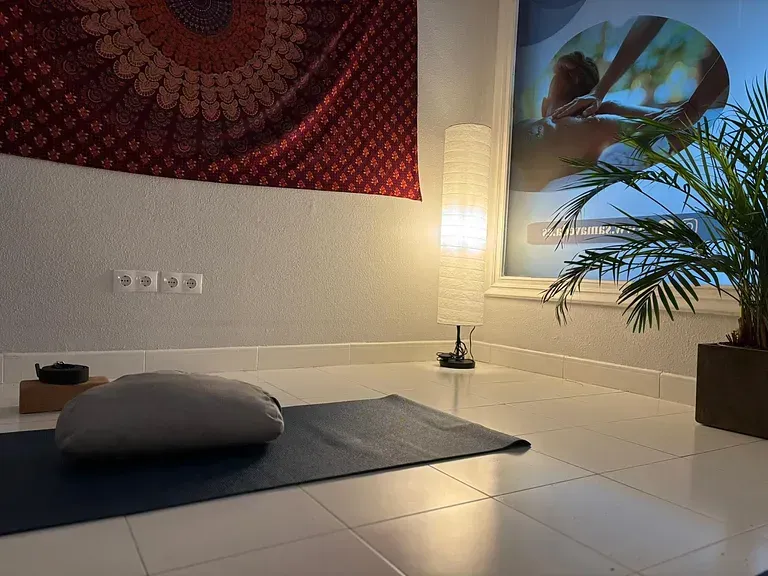 Hay una esterilla de yoga en el suelo en el medio de la habitación.