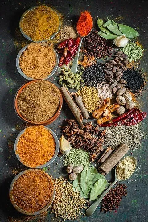 Una variedad de especias en cuencos y cucharas sobre una mesa.