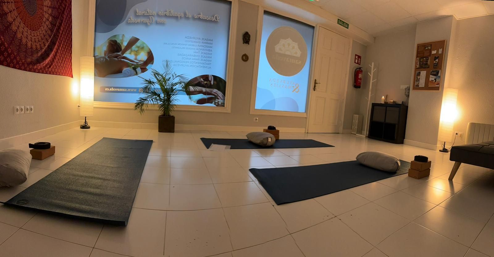 Una habitación con muchas colchonetas de yoga en el suelo.