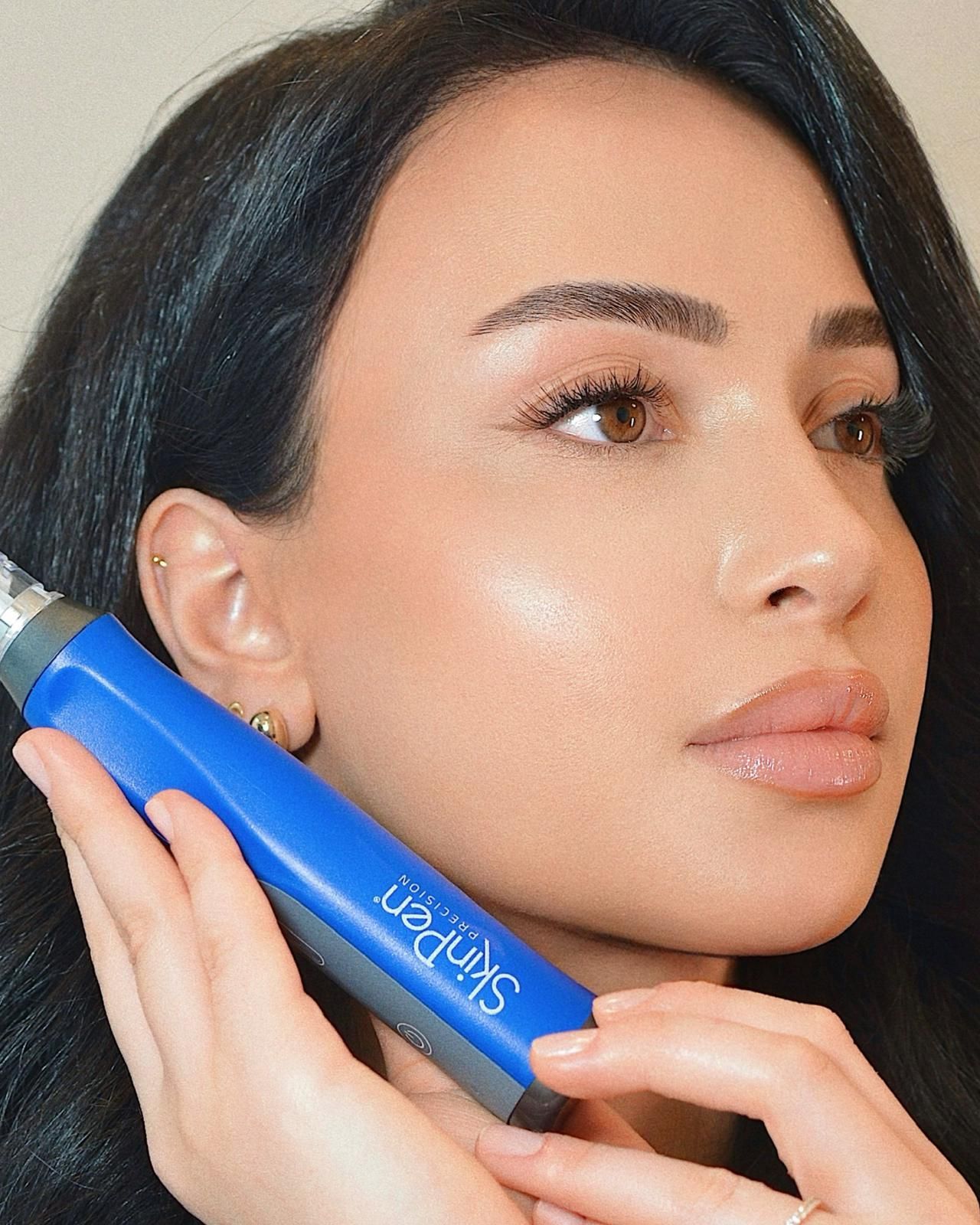 Ein blaues SkinPen-Mikroneedling-Gerät neben einer Nahaufnahme einer Person, die ihr Gesicht berührt, mit dem Text „Der weltweit führende Microneedling Pen“.