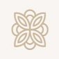 Ein beigefarbenes, symmetrisches, vierblättriges Blumenmotiv mit abgerundeten Kanten, zentriert auf einem hellen, einfarbigen Hintergrund.