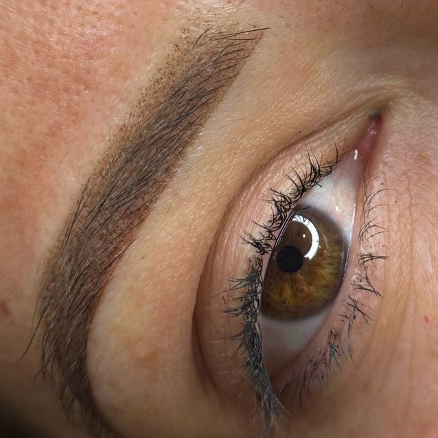 Nahaufnahme einer Person, die von einer Technikerin mit schwarzen Handschuhen eine kosmetische Lippentätowierung erhält.