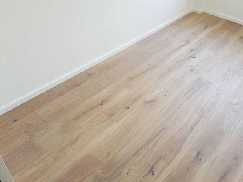 Ein Raum mit Holzboden und weißen Wänden.