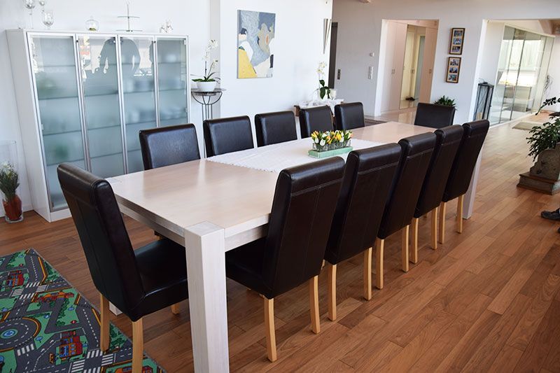 Ein langer Esstisch mit schwarzen Stühlen in einem Wohnzimmer