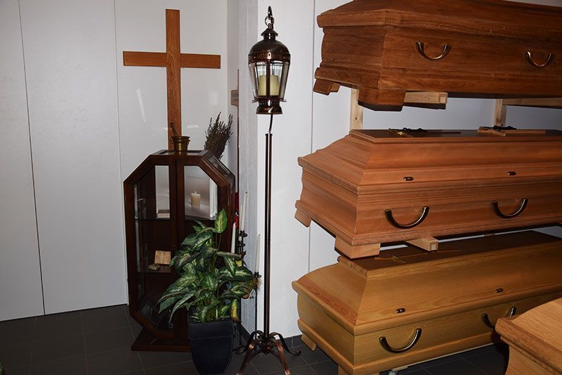 Ein Raum voller Holzsärge und eines Kreuzes.