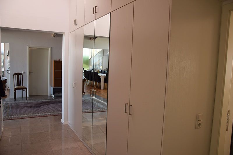 Ein Flur mit vielen Schränken und Spiegeln