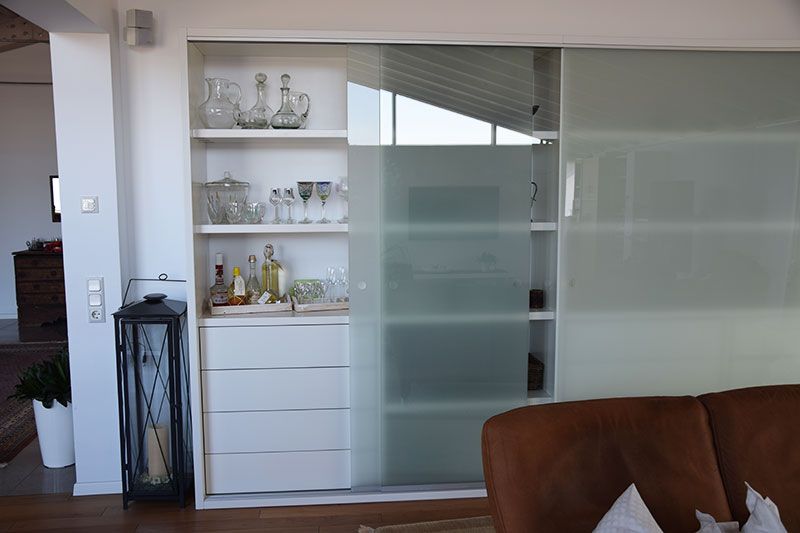 Ein Wohnzimmer mit einem Schrank mit Glasschiebetür