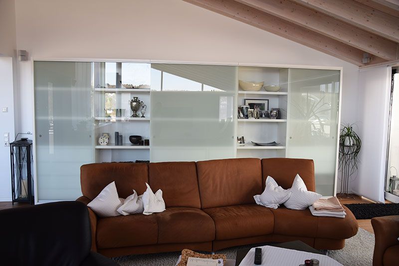 Ein Wohnzimmer mit einem Schrank mit Glasschiebetür