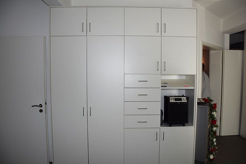 Ein Raum mit vielen weißen Schränken und Schubladen