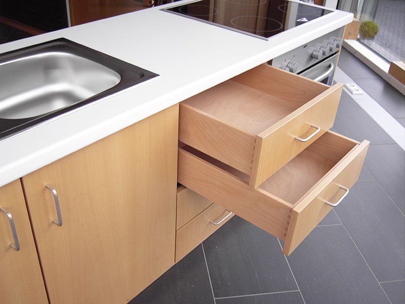 Eine Küche mit Spüle und zwei offenen Schubladen