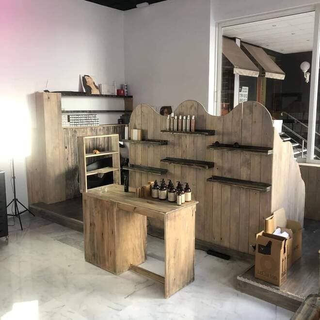 Estanterías y mostrador de madera rústica en el interior de una tienda luminosa y vacía.