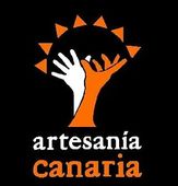 Logo de Artesanía Canaria: mano blanca y naranja bajo semicírculo de triángulos naranjas sobre fondo negro
