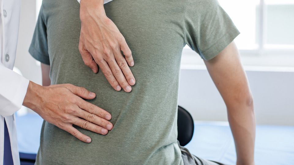 Physiotherapeut tastet einen Rücken ab