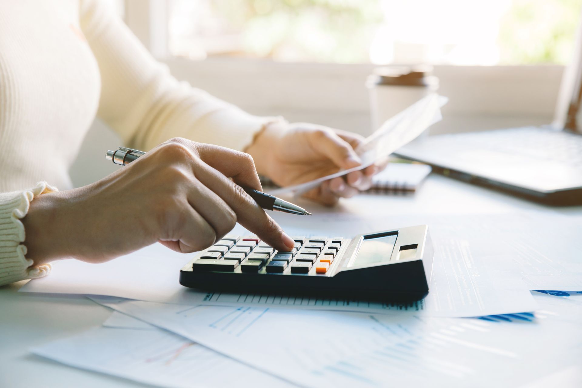 Gros plan sur une personne qui exécute un calcul à l'aide d'une calculatrice